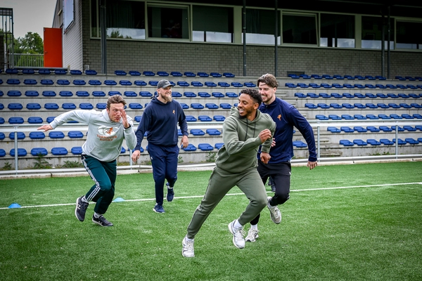 tometh jongeren rennen het veld op